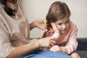 Mãe tentando limpar o ouvido da filha para remover a cera