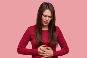 Mulher com dor na barriga por causa de refluxo