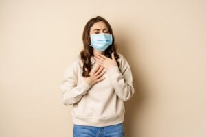 Moça usando máscara por estar com sintomas de síndrome respiratória aguda