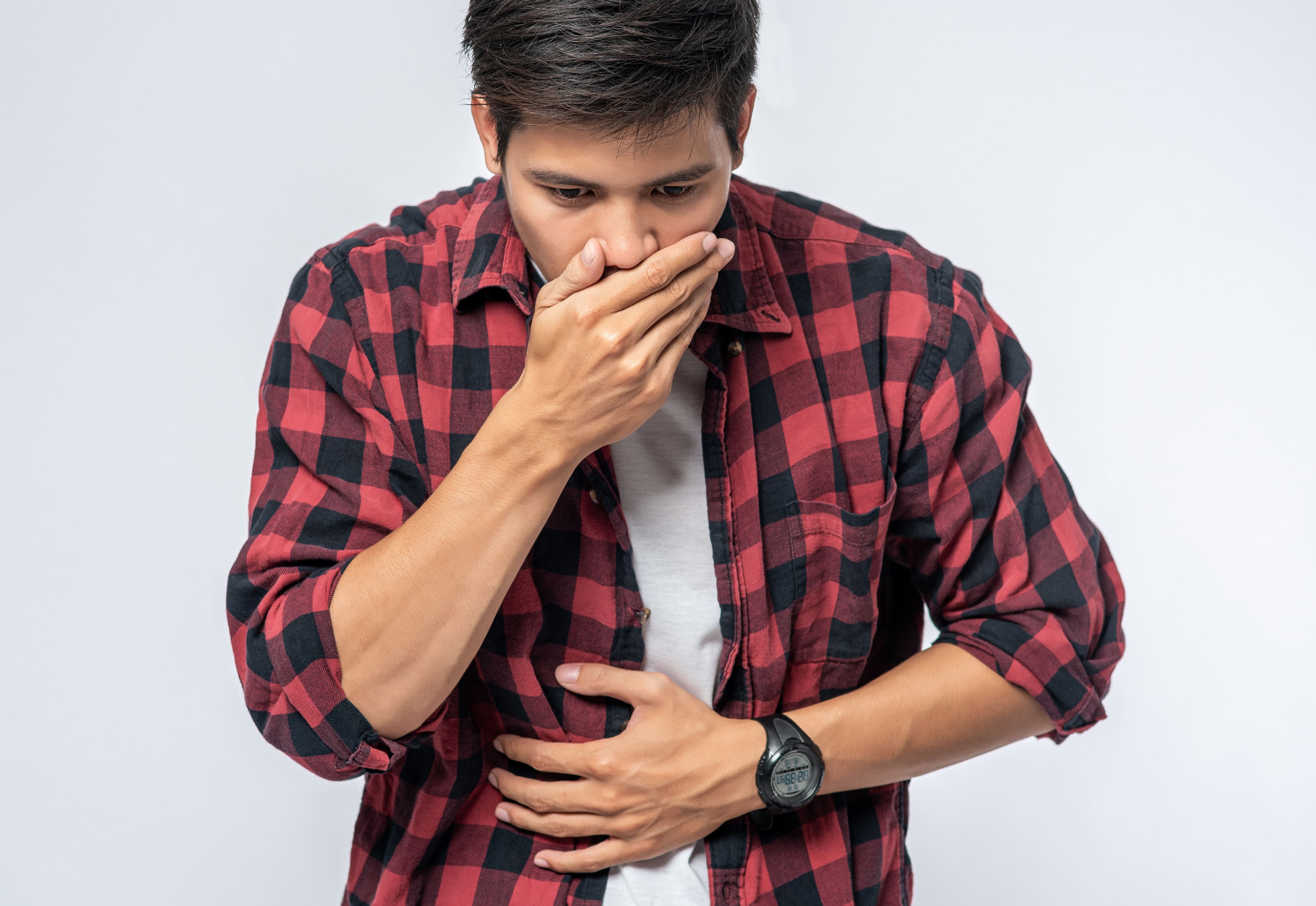 Rapaz sentindo azia e refluxo por problemas gastrointestinais