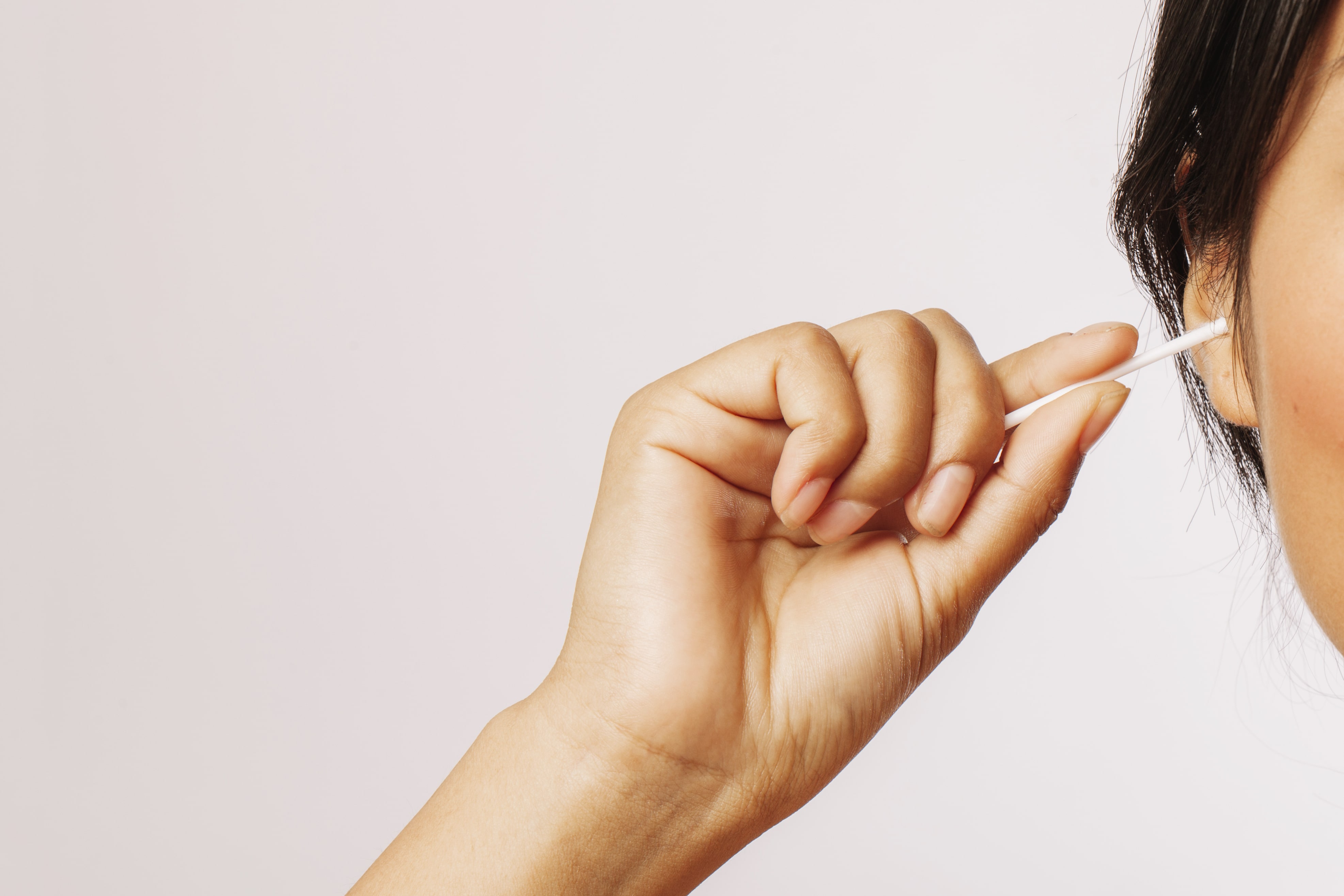 Pessoa limpando seu ouvido para tirar cera de ouvido